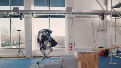 The image, taken from the viral video, shows a robot named Atlas delivering tools to a man. (YouTube/@Boston Dynamics)