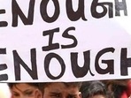 Representational image of a person holding up a banner to protest on crimes against women. Representational image of a person holding up a banner to protest on crimes against women.