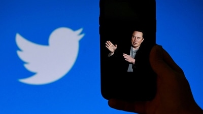 A phone screen displays a photo of Elon Musk with the Twitter logo shown in the background, in Washington, DC. (AFP) A phone screen displays a photo of Elon Musk with the Twitter logo shown in the background, in Washington, DC. (AFP)