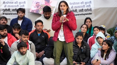 Wrestler Vinesh Phogat speaks as wrestlers Sakshi Malik and Bajrang Punia look on during their ongoing protest against the Wrestling Federation of India (WFI), at Jantar Mantar in New Delhi on Friday, (PTI) Wrestler Vinesh Phogat speaks as wrestlers Sakshi Malik and Bajrang Punia look on during their ongoing protest against the Wrestling Federation of India (WFI), at Jantar Mantar in New Delhi on Friday, (PTI)