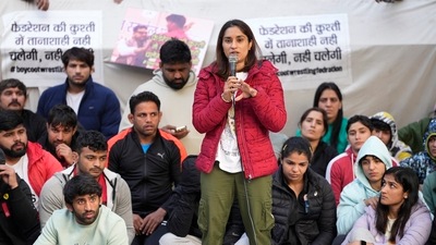 Wrestler Vinesh Phogat speaks as wrestlers Sakshi Malik and Bajrang Punia look on during their ongoing protest against the Wrestling Federation of India (WFI), at Jantar Mantar in New Delhi on Friday, (PTI)