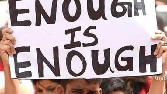 Representational image of a person holding up a banner to protest on crimes against women.