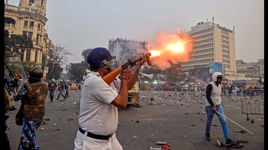 A policeman fires teargas shells during clashes with ISF members following their rally, in Kolkata on Saturday. (PTI)