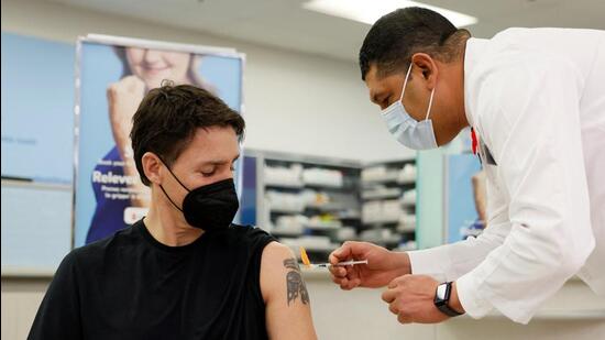 Canada's Prime Minister Justin Trudeau receives a Covid-19 booster, followed by a flu vaccine, at a pharmacy in Ottawa, Ontario (REUTERS/FILE)