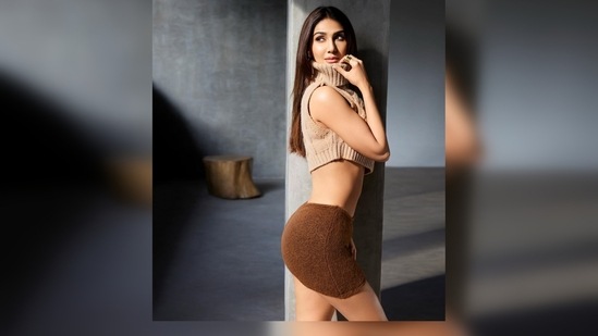 For her recent photoshoot, Vaani Kapoor donned a beige cropped sleeveless turtleneck and a brown mini low-rise warm skirt. (Instagram/@_vaanikapoor_)