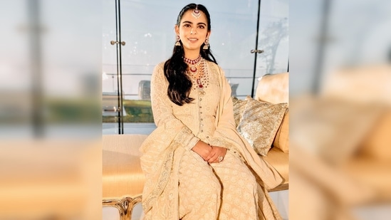 Isha Ambani amped up her regal look with a heavy red-studded necklace with diamonds, maang tikka and jhumkas. (Instagram/@stylebyami)