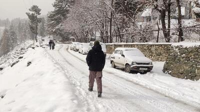 People walk on a snow-covered road as the area receives fresh snowfall, at Tangmarg, in Baramulla on Sunday. (ANI) People walk on a snow-covered road as the area receives fresh snowfall, at Tangmarg, in Baramulla on Sunday. (ANI)