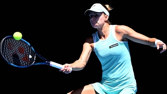 Magda Linette hits a return against Caroline Garcia during their women's singles match on day eight of the Australian Open(AFP)