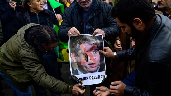 Protesters burn a portrait of Rasmus Paludan, leader of Danish far-right political party Hard Line, in front of the Consulate General of Sweden in Istanbul on January 22, 2023, after Rasmus Paludan, who also has Swedish citizenship, burned a copy of the Koran near the Turkish Embassy in Stockholm. - Sweden's prime minister has condemned as "deeply disrespectful" the weekend burning of a Koran in Stockholm, which has raised tensions with Turkey as the Nordic country courts Ankara over its NATO bid. (Photo by Yasin AKGUL / AFP)(AFP)