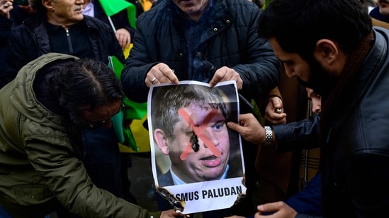 Protesters burn a portrait of Rasmus Paludan, leader of Danish far-right political party in Istanbul on Sunday. (AFP)