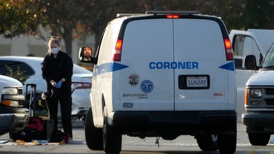 A forensic lab investigator takes her gloves off as the body of Huu Can Tran is retrieved from a van by the Los Angeles County coroner in Torrance, California, Sunday, January 22, 2023. (AP Photo/Damian Dovarganes)