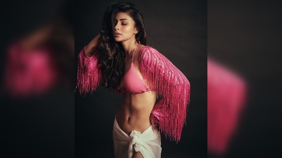 Mouni Roy's latest photoshoot pictures feature her in a pink bikini top, a tassel arm shrug and a sheer white beach over. (Instagram/@imouniroy)
