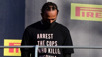FILE PHOTO: Formula One F1 - Tuscan Grand Prix - Mugello, Scarperia e San Piero, Italy - September 13, 2020 Mercedes' Lewis Hamilton wears a shirt in reference to Breonna Taylor on the podium as he celebrates after winning the race Pool via REUTERS/Jennifer Lorenzini/File Photo (Pool via REUTERS)