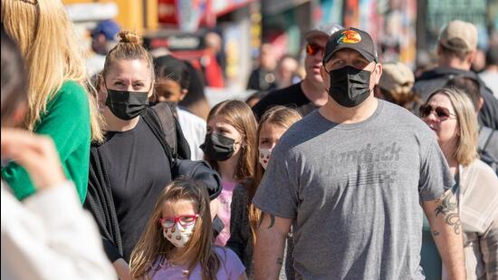 Crowds of people walking down the streets of Clifton Hill wearing masks in Niagara Ontario, Canada last year. (Matthew Zuech/Shutterstock.com)