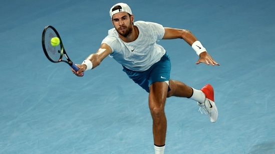 Russia's Karen Khachanov hits a return against USA's Sebastian Korda during their men's singles quarter-final match on day nine of the Australian Open tennis tournament in Melbourne on January 24, 2023. (Photo by DAVID GRAY / AFP) / -- IMAGE RESTRICTED TO EDITORIAL USE - STRICTLY NO COMMERCIAL USE --(AFP)