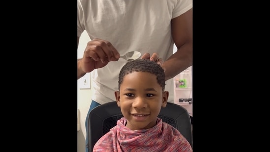 Dad giving his son a haircut using the spoon. (Instagram/@ari_rover)