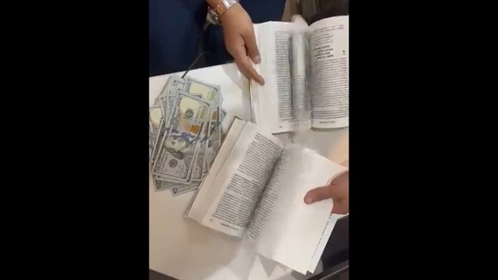 Over $90,000 cash was found concealed within pages of a book.(ANI)