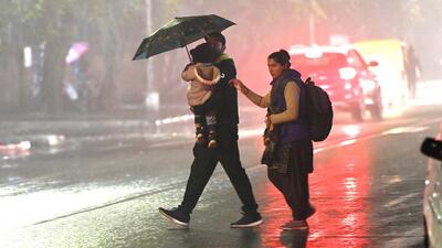City residents crossing a road amid the downpour in Sector 19, Chandigarh, on Wednesday. (Keshav Singh /HT)