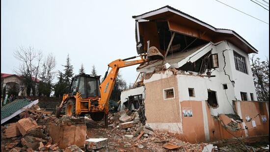 A portion of house belonging to NC leader Ali Muhammad Sagar’s wife being razed on Wednesday. (Waseem Andrabi/ Hindustan Times)