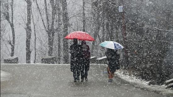 People walk amid snowfall in Srinagar on Wednesday. (Waseem Andrabi/ HT)