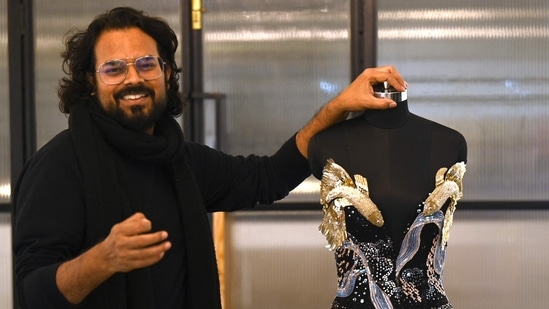 In this photograph taken on January 13, 2023, Indian fashion designer Rahul Mishra stands beside his new collection at his workshop in Noida. - For a man with seemingly infinite creative ambitions, it is fitting that Indian designer Rahul Mishra's latest Paris haute couture collection attempts to encapsulate the entire universe. (Photo by Money SHARMA / AFP)(AFP)