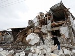 Local residents remove debris from a house of their  neighbour damaged by a Russian military strike, amid Russia's attack on Ukraine.