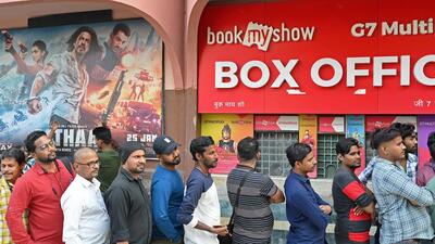 Moviegoers stand in a queue as they wait to watch Bollywood movie 'Pathaan' at a cinema hall. (AFP)
