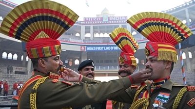 Indian Border Security Force (BSF) soldiers pose while offering sweets to each other during the celebrations to mark country's Republic Day at the India-Pakistan Wagah border post, about 35km from Amritsar on January 26, 2023. (Photo by Narinder NANU / AFP) (AFP)