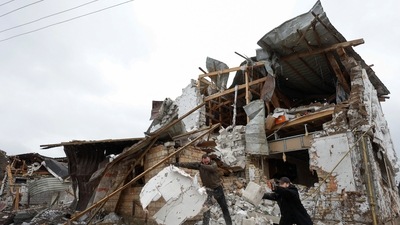 Local residents remove debris from a house of their  neighbour damaged by a Russian military strike, amid Russia's attack on Ukraine. (REUTERS)