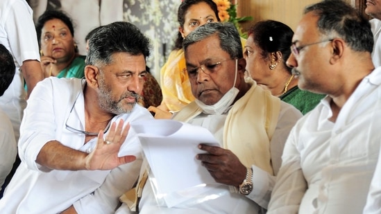 Karnataka Congress President DK Shivakumar interacting with Leader of Opposition in Karnataka Legislative Assembly Siddaramaiah. (ANI Photo) (Shashidhar Byrappa)