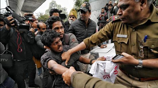 Delhi Police personnel detain students outside the Jamia Millia Islamia University in New Delhi on Wednesday. (Sanchit Khanna/HT Photo)