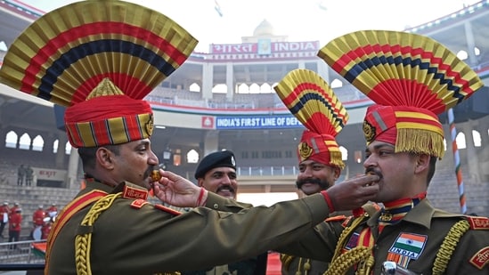 Indian Border Security Force (BSF) soldiers pose while offering sweets to each other during the celebrations to mark country's Republic Day at the India-Pakistan Wagah border post, about 35km from Amritsar on January 26, 2023. (Photo by Narinder NANU / AFP)(AFP)