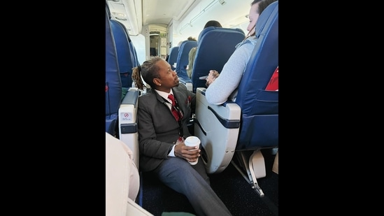Delta flight attendant Floyd Dean-Shannon comforting a distressed passenger. (Facebook/Molly Simonson Lee)