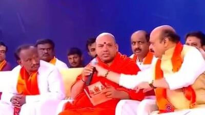 Karnataka chief minister and seer Eshwaranandapuri Swami were on the stage at a religious event in Bengaluru’s Mahadevapura on Thursday. (Video grab) Karnataka chief minister and seer Eshwaranandapuri Swami were on the stage at a religious event in Bengaluru’s Mahadevapura on Thursday. (Video grab)