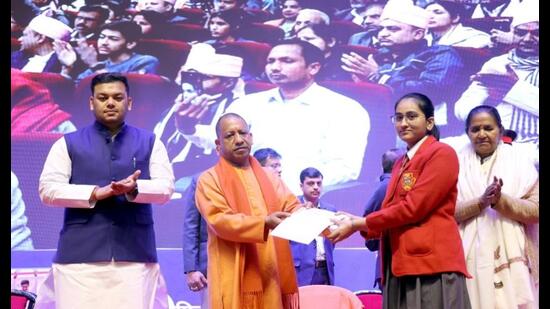 Chief minister Yogi Adityanath honours a meritorious student at a function in Lucknow on Friday. (Sourced)