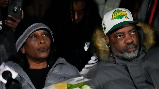 RowVaughn Wells, mother of Tyre Nichols, who died after being beaten by Memphis police officers, and his stepfather Rodney Wells, listen to speakers at a candlelight vigil for Nichols in Memphis, Tennessee on Thursday.(AP)