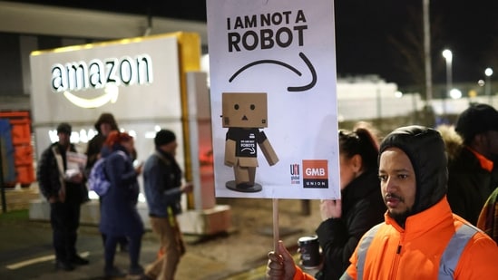 A man holds a sign during a rally in support of Amazon workers' on strike, outside the Amazon warehouse, in Coventry, Britain, Wednesday.(REUTERS)