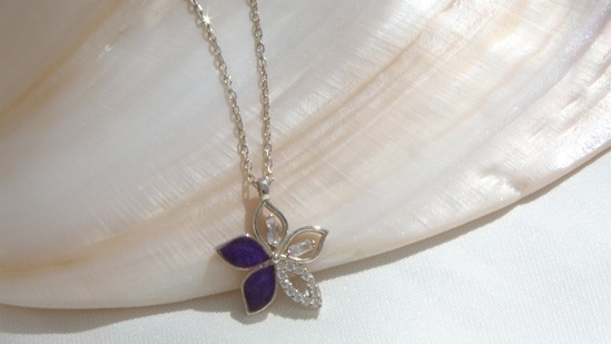 A flower pendant necklace looks dainty and elevates the look. (Pexels)
