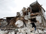 Local residents remove debris from a house of their  neighbour damaged by a Russian military strike, amid Russia's attack on Ukraine.