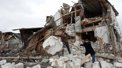 Local residents remove debris from a house of their  neighbour damaged by a Russian military strike, amid Russia's attack on Ukraine. (REUTERS)