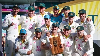 Australia�s captain Pat Cummins (C) holds the trophy as he poses with team mates after the third cricket Test match between Australia and South Africa at the Sydney Cricket Ground (SCG) in Sydney on January 8, 2023. (Photo by DAVID GRAY / AFP) / -- IMAGE RESTRICTED TO EDITORIAL USE - STRICTLY NO COMMERCIAL USE -- (AFP)
