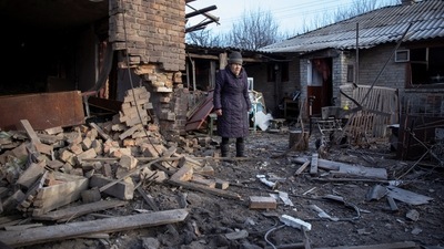 Local resident Yevheniia Yepifanova, 83, stands next to her house damaged by a Russian military strike, amid Russia's attack on Ukraine, in Chasiv Yar, Donetsk region, Ukraine. (REUTERS)