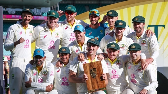 Australia�s captain Pat Cummins (C) holds the trophy as he poses with team mates after the third cricket Test match between Australia and South Africa at the Sydney Cricket Ground (SCG) in Sydney on January 8, 2023. (Photo by DAVID GRAY / AFP) / -- IMAGE RESTRICTED TO EDITORIAL USE - STRICTLY NO COMMERCIAL USE --(AFP)