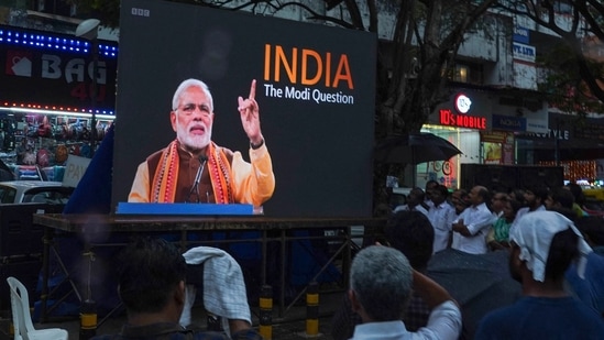 People watch the BBC documentary "India: The Modi Question", on a screen.(AFP)