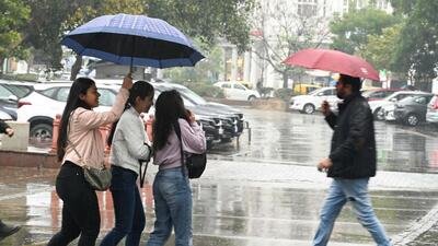 New Delhi , India - Jan. 29, 2023: People seen with umbrella's during light rain drizzles at Connaught Place, in New Delhi , India, on Sunday. (Hindustan Times) New Delhi , India - Jan. 29, 2023: People seen with umbrella's during light rain drizzles at Connaught Place, in New Delhi , India, on Sunday. (Hindustan Times)