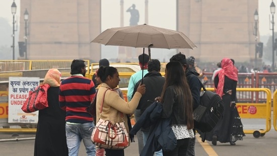 People visiting India Gate on Sunday morning amid light rain shower.(Vipin Kumar/HT Photo)