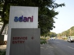 Vehicles move past a signage near the entrance of Adani Corporate House in Ahmedabad,(AP) Vehicles move past a signage near the entrance of Adani Corporate House in Ahmedabad,(AP)