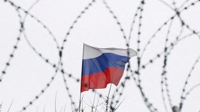 The Russian flag is seen through barbed wire. (Reuters)