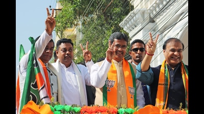 Tripura chief minister Manik Saha with Assam chief minister Himanta Biswa Sarma and BJP national spokesperson Sambit Patra show a victory sign during the roadshow in Agartala on Monday. (ANI)