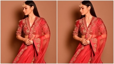 Mouni looked every bit gorgeous in the red silk blouse featuring long sleeves and a plunging neckline, decorated in golden zari details and embroidery work in golden resham threads. (Instagram/@imouniroy) Mouni looked every bit gorgeous in the red silk blouse featuring long sleeves and a plunging neckline, decorated in golden zari details and embroidery work in golden resham threads. (Instagram/@imouniroy)